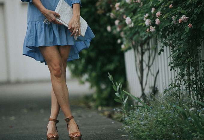 blue dress with white clutch